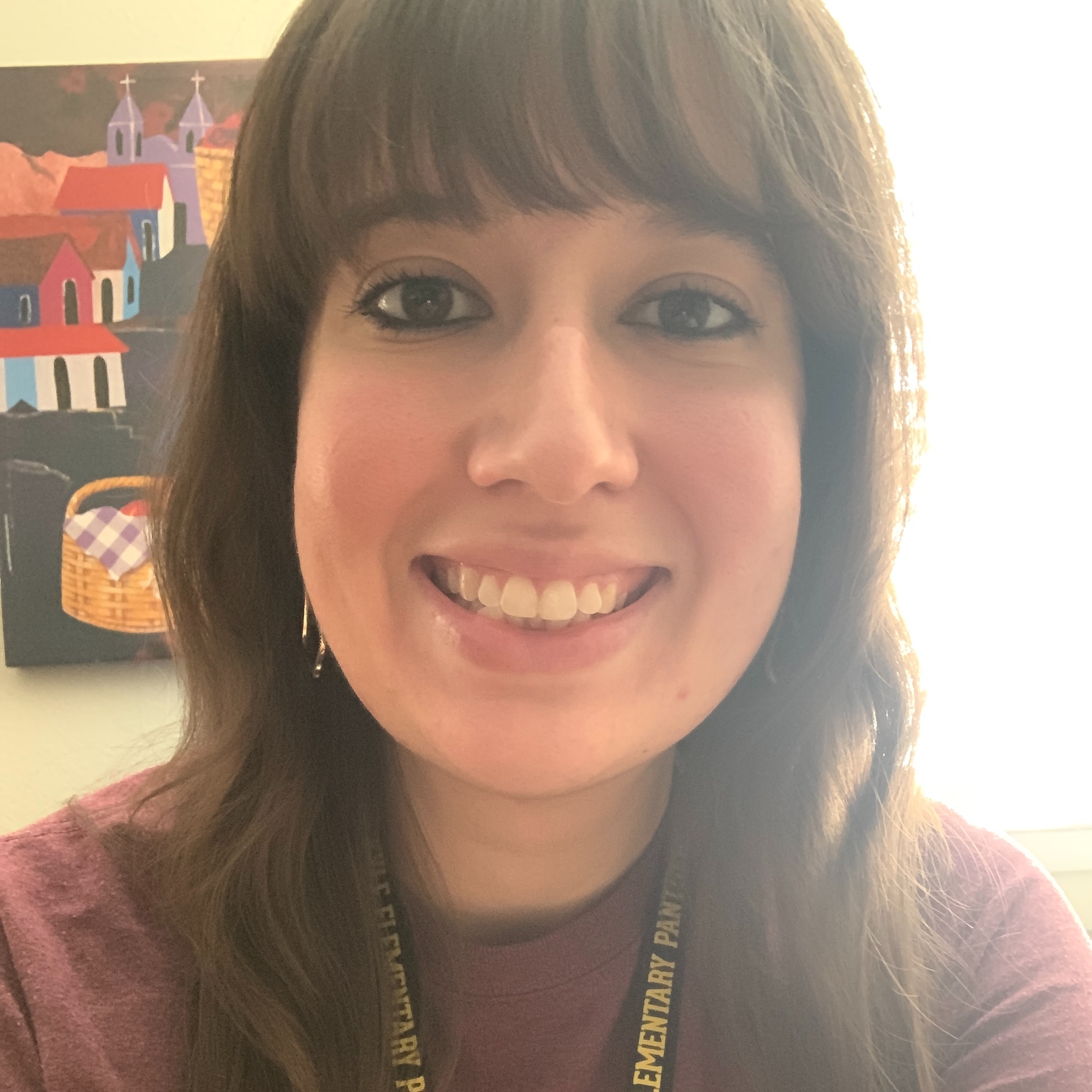 A woman with dark brown hair smiling for a photo.