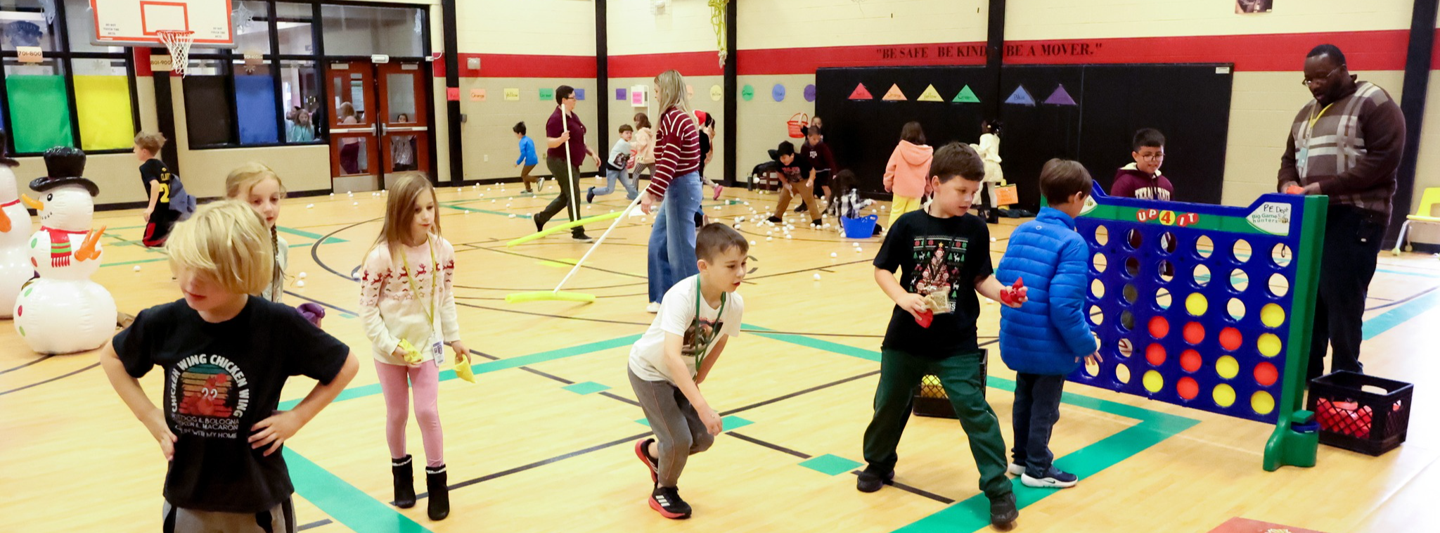 A group of elementary students in the gym engaging in activities