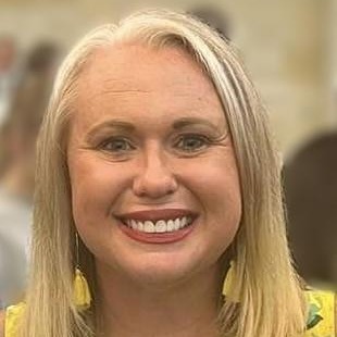 A woman with short blonde hair smiling
