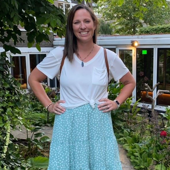 A woman wearing a white shirt and a blue skirt