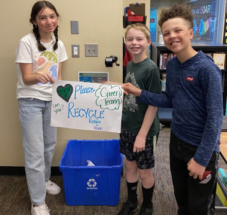 students smiling holding a papoer