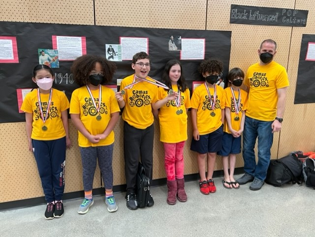 A group of young people proudly displaying their medals and ribbons.