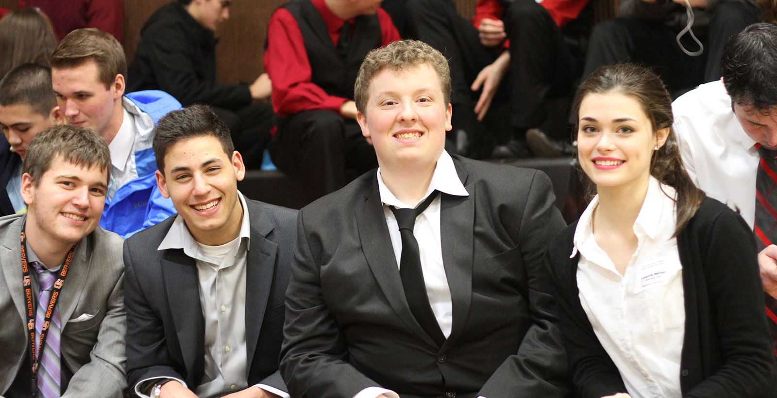 4 students smiling in suits