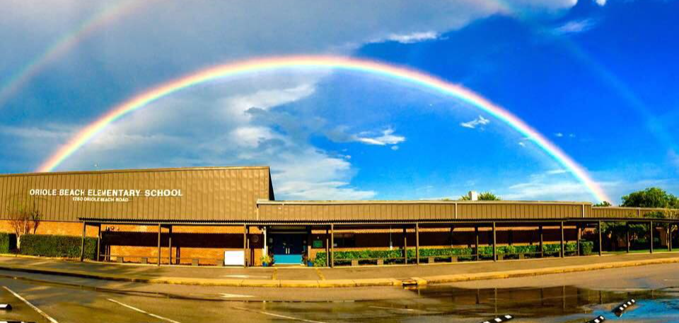 oriole beach elementary front of the school with a double rainbow over the building