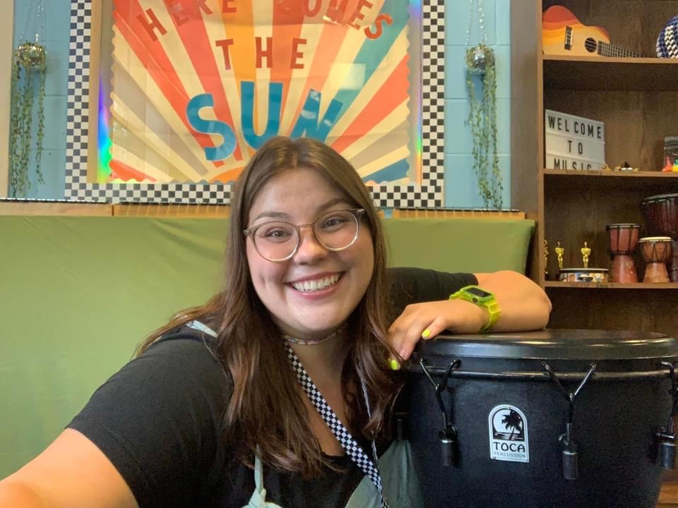 Ms. Richbourg smiling while leaning on a drum