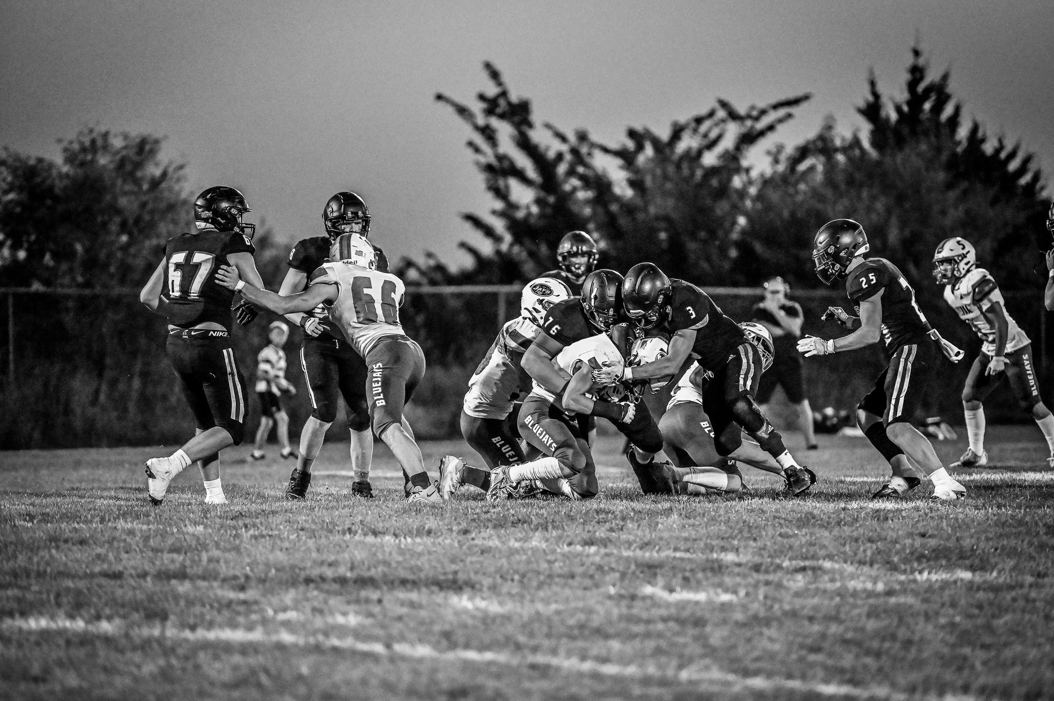 football team tackling in game - black and white photo