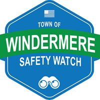 A blue hexagonal logo featuring the text 'TOWN OF WINDERMERE' at the top, 'SAFETY WATCH' in large green letters, and an icon of binoculars at the bottom.
