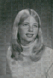 A black and white portrait of a young woman with long, straight hair, wearing a light-colored sweater, smiling softly at the camera.