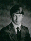 A black and white portrait of a young man in a suit and tie, with short hair and a serious expression, typical of a school yearbook photo.