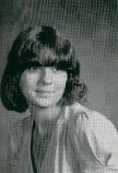 A black and white portrait of a young woman with shoulder-length hair and bangs, wearing a light-colored top, posed slightly to the side.