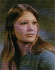 A young woman with long, straight hair, wearing a blue sweater, gazes thoughtfully to the side against a blurred background.