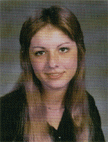 A young woman with long, straight hair and a slight smile, wearing a black top, posed for a school portrait against a neutral background.