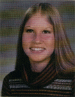 A young woman with long, straight hair and a friendly smile, wearing a striped sweater, posed for a school photo against a blurred background.