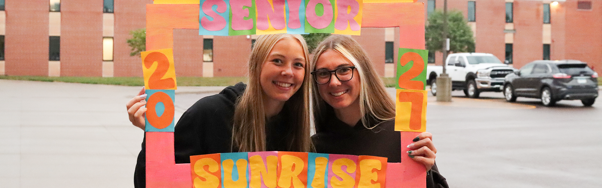 seniors pose with senior sunset banner