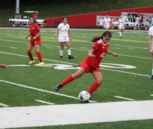 girls playing soccer at field
