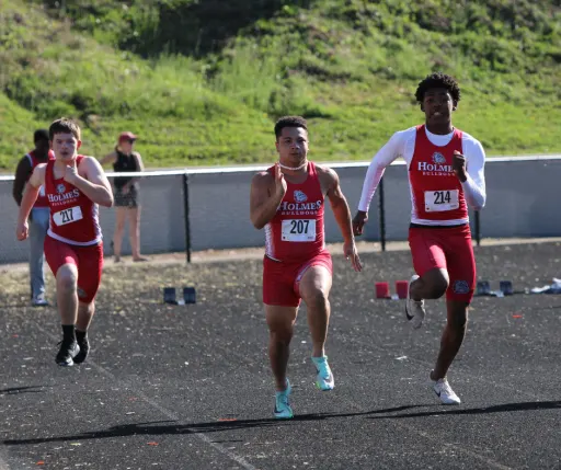3 boys running on the field