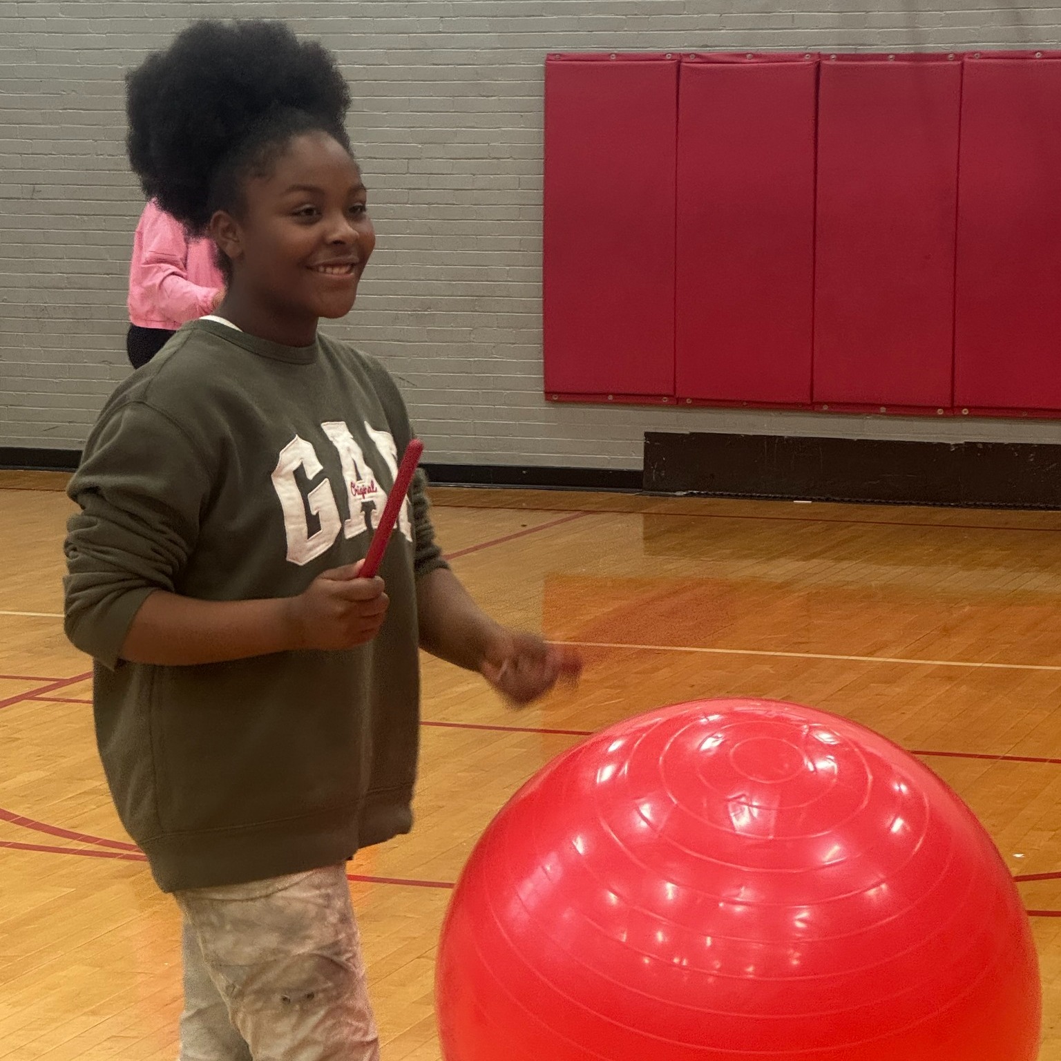 girl playing drums on a large ball