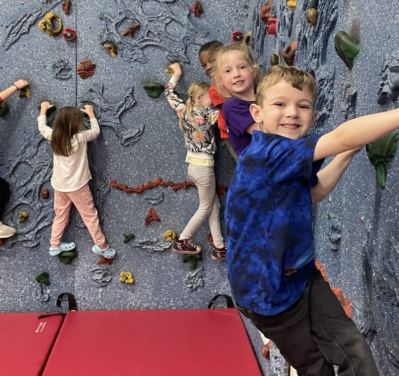 kids hiking on an indor gym smiling and posing for a photo
