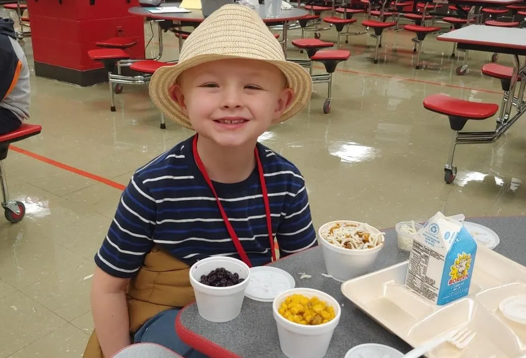 student smiling taking lunch on the cafeteria