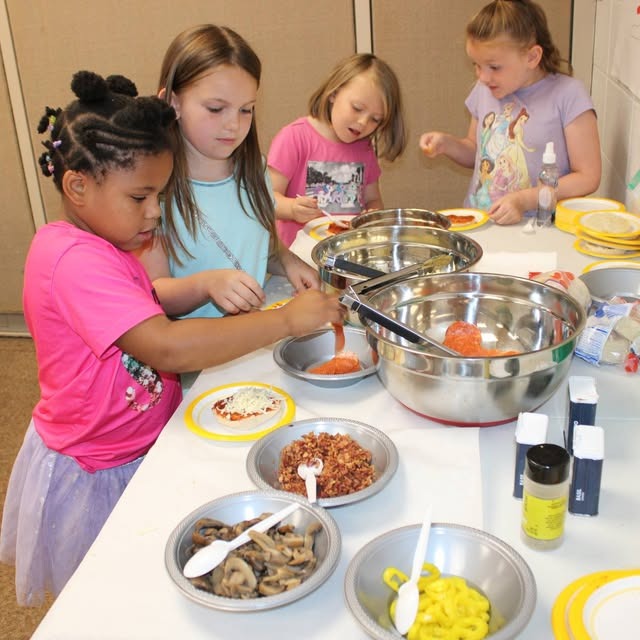 girls create their own pizzas