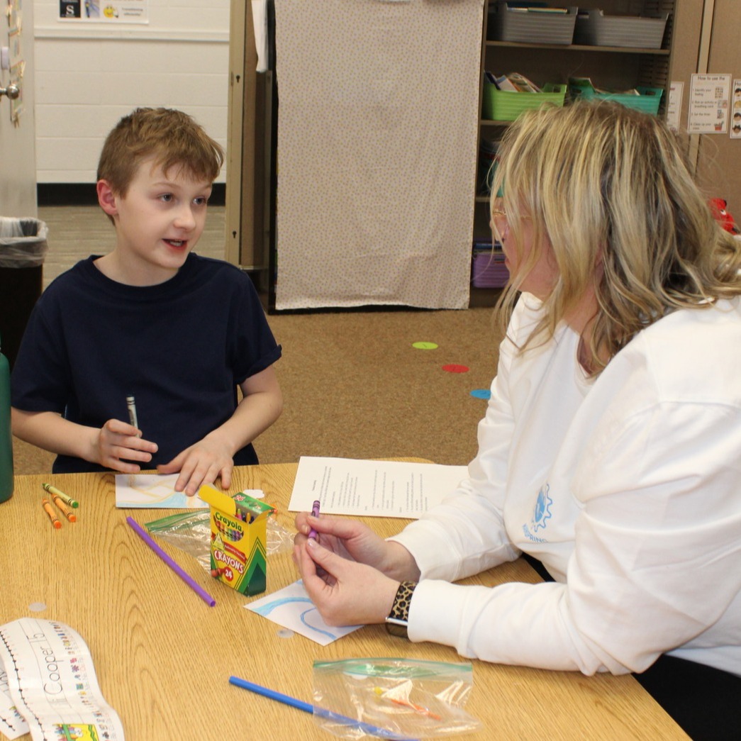 a boy talking to an adult