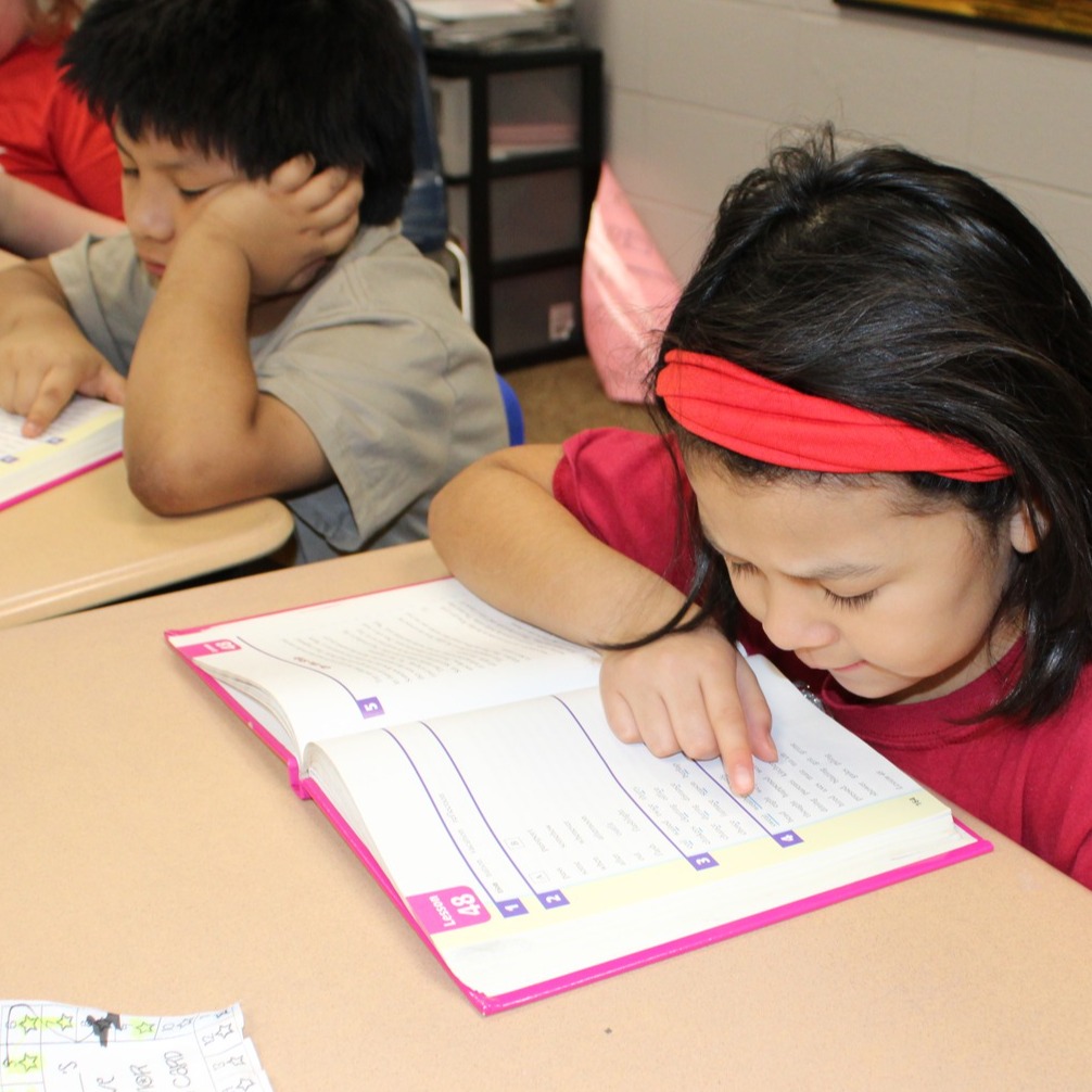 young girl reading a workbook