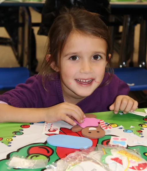 child smiling assembling a ginger bread cookie
