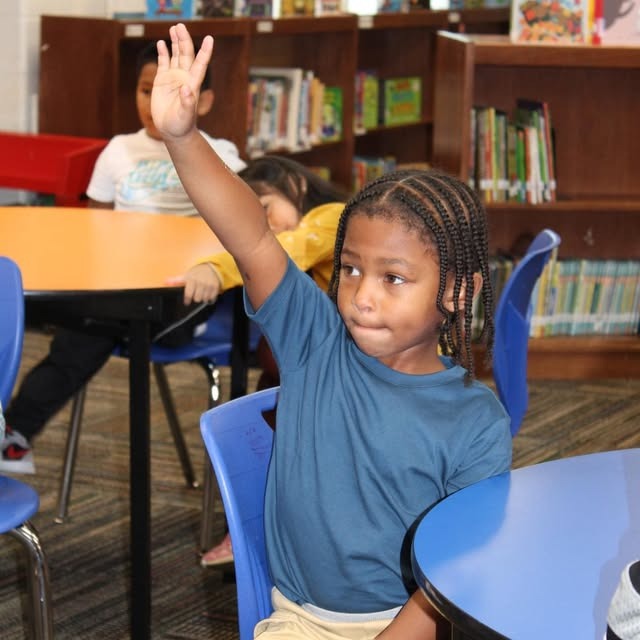 young male student raising his hand