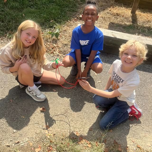 three students playing outside