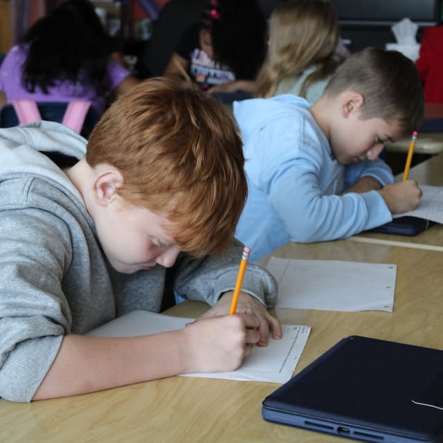 two young boys doing school work