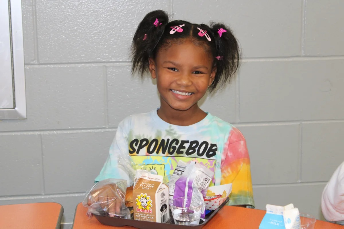 student smiling having lunch at cafeteria