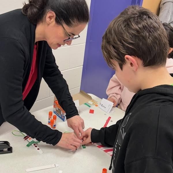 female adult helps young male student