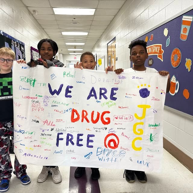 four students hold up a We are Drug Free sign