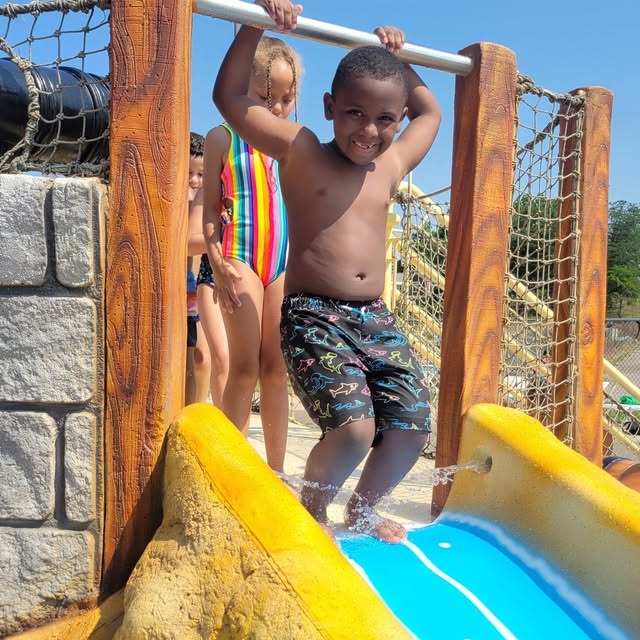 young male student gets ready to go down water slide
