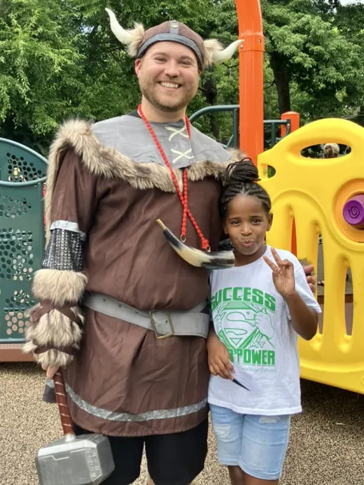 man with a vivking suit and student smiling posing for the camara