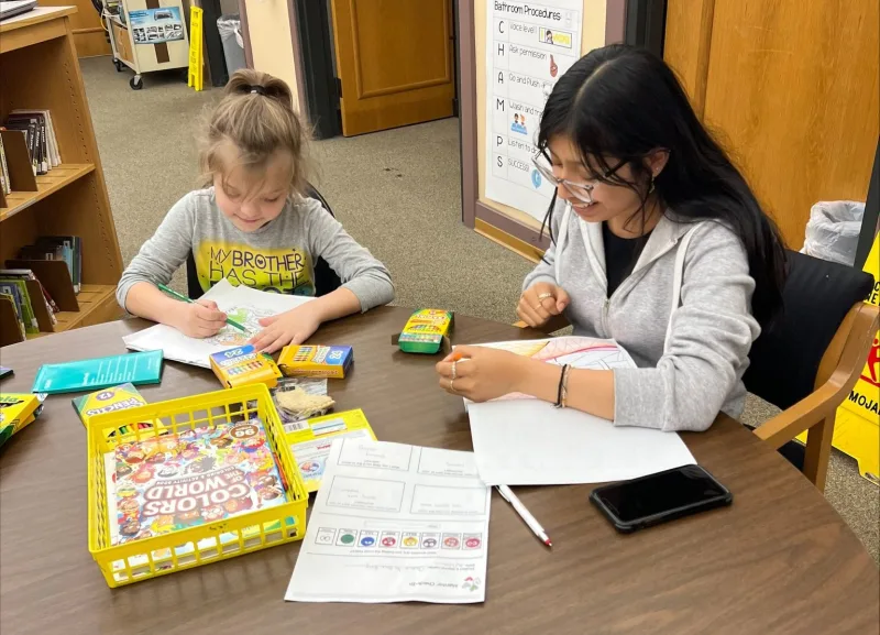 2 students colouring at library