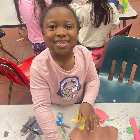 young female student cutting paper