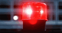 A red light illuminates a street light, casting a vibrant glow on the surrounding area at night.