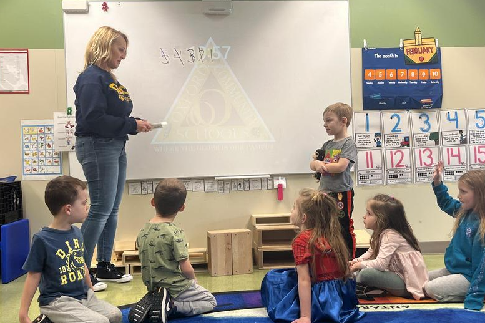 Teacher in front of preschool class teaching a lesson.