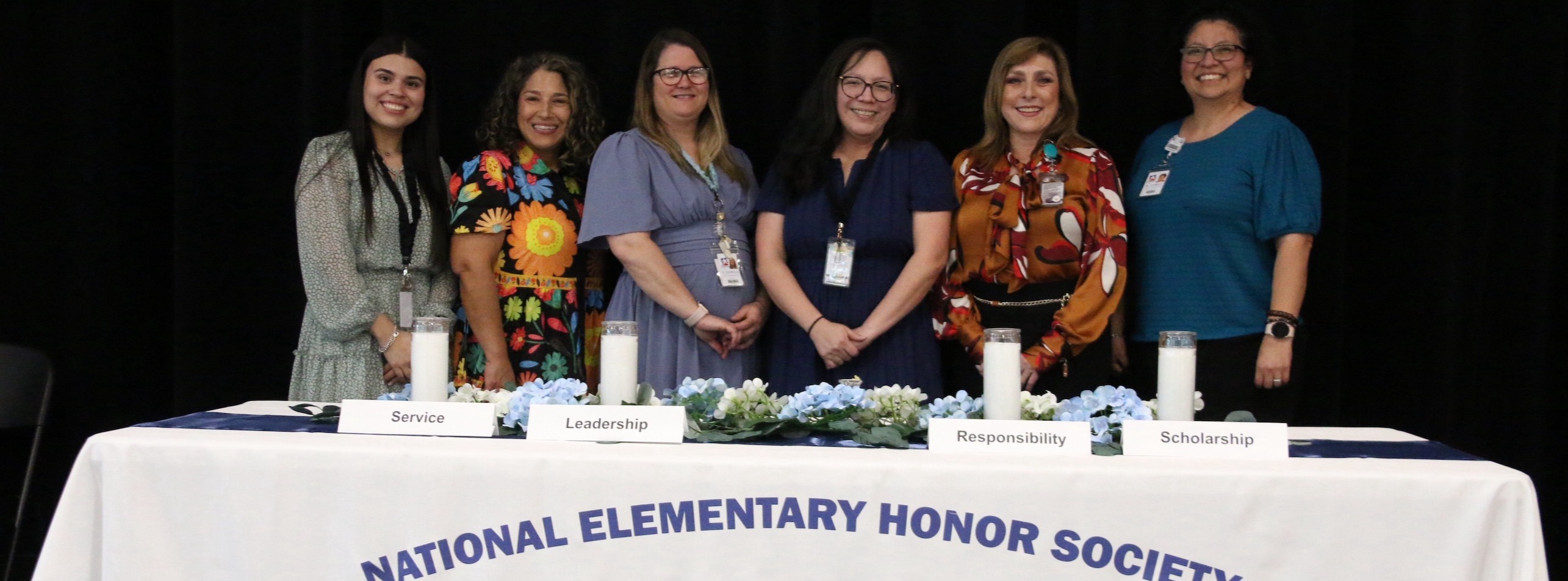 Ramage Elementary School administration posting for a group photo with a table decorated in National Elementary Honor Society