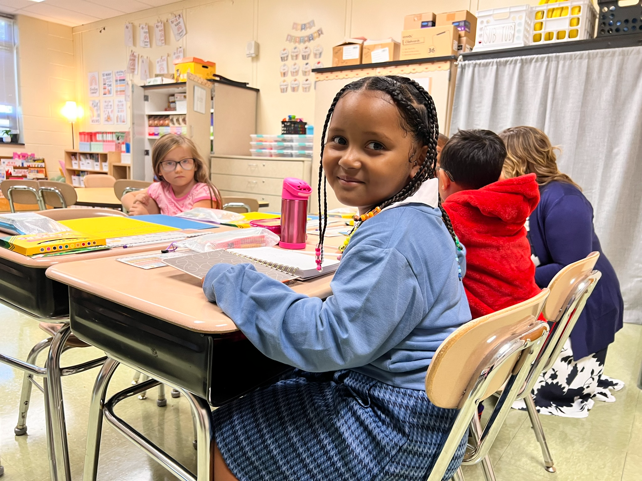 Smiling student sitting in a classroom desk