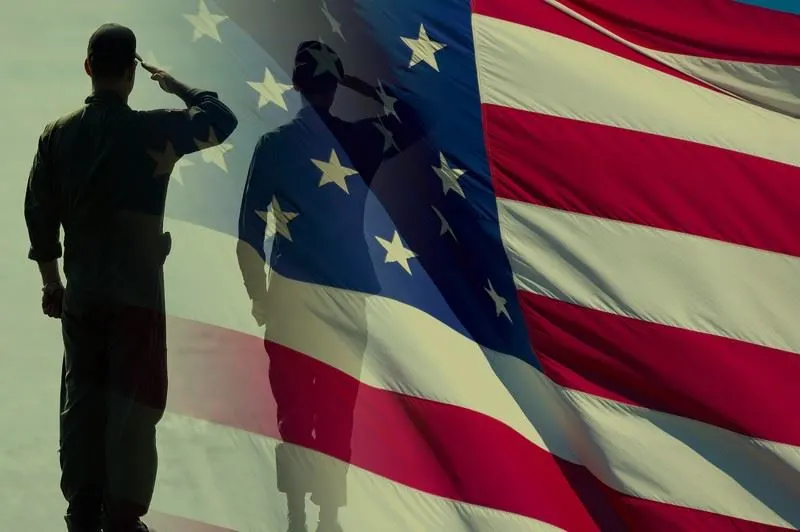 A soldier salutes in front of a waving American flag, symbolizing patriotism and honor.