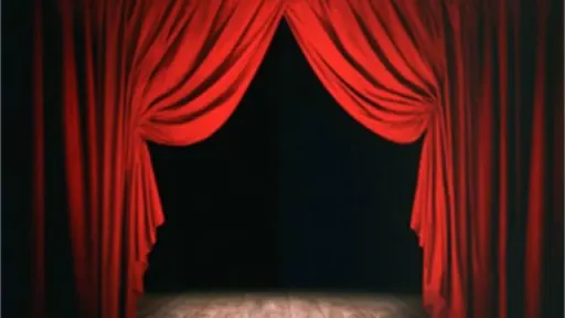 A luxurious red curtain drapes open to reveal a dark stage, inviting anticipation for a performance about to begin.