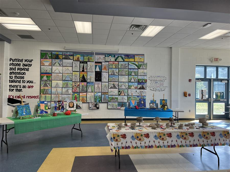 A vibrant hallway adorned with numerous colorful paintings lining the walls, creating an inviting and artistic atmosphere.