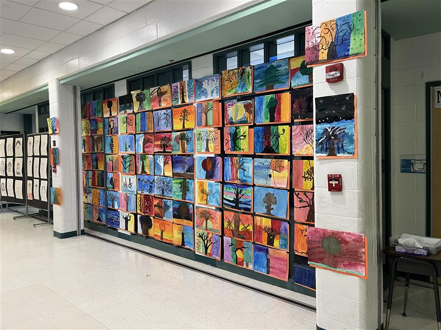A vibrant hallway adorned with numerous colorful paintings lining the walls, creating an inviting and artistic atmosphere.