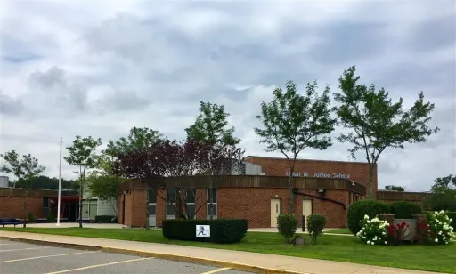 A large brick building surrounded by trees and bushes, creating a serene and inviting outdoor environment.