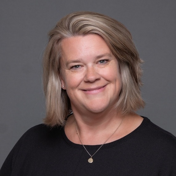 a woman with short blonde hair wearing a black shirt