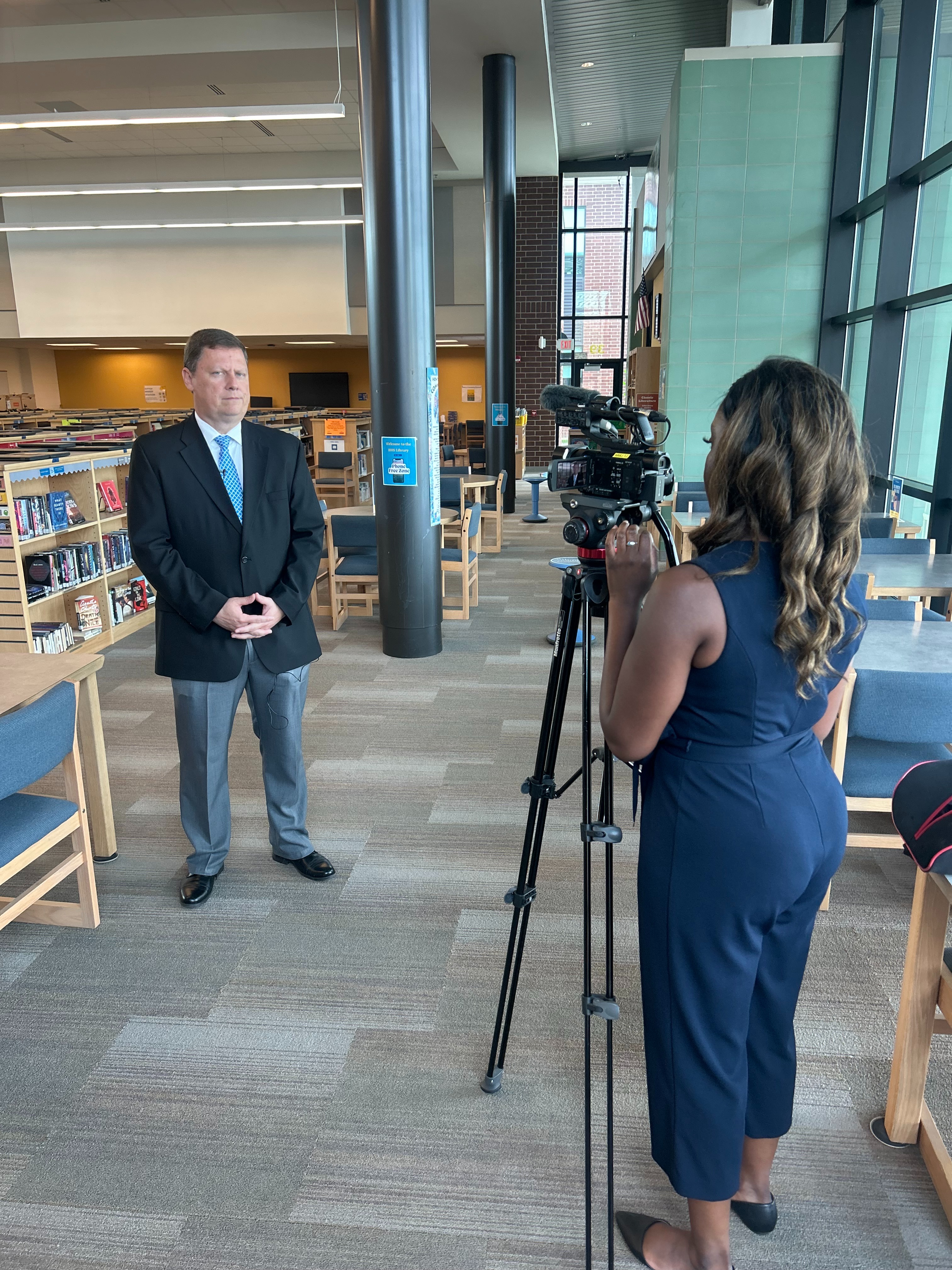 A man is being interviewed by a news reporter with a camera
