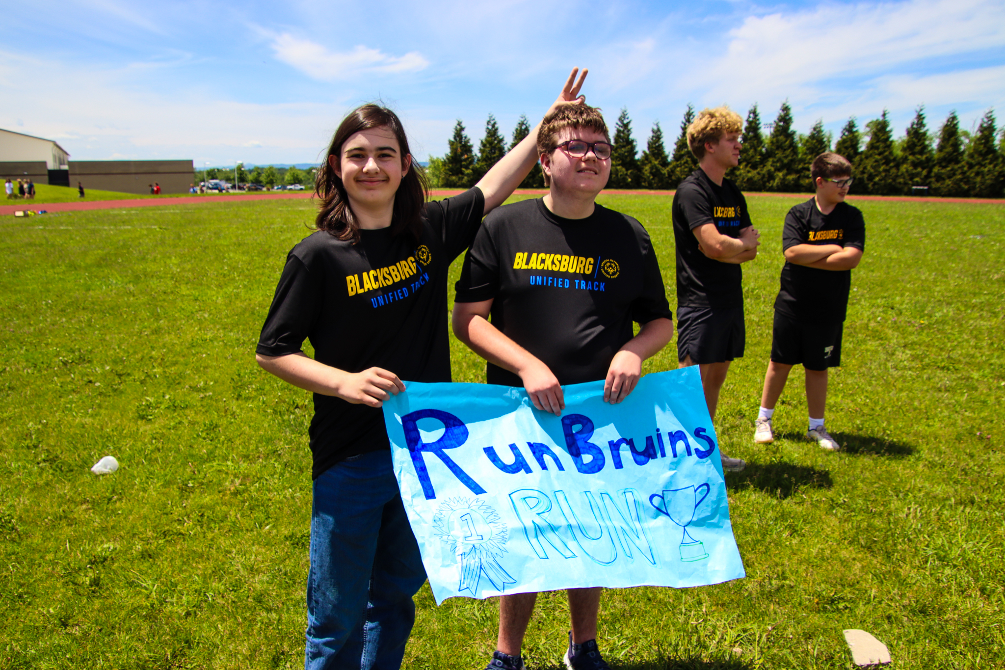 Two students smiling and holding a sign