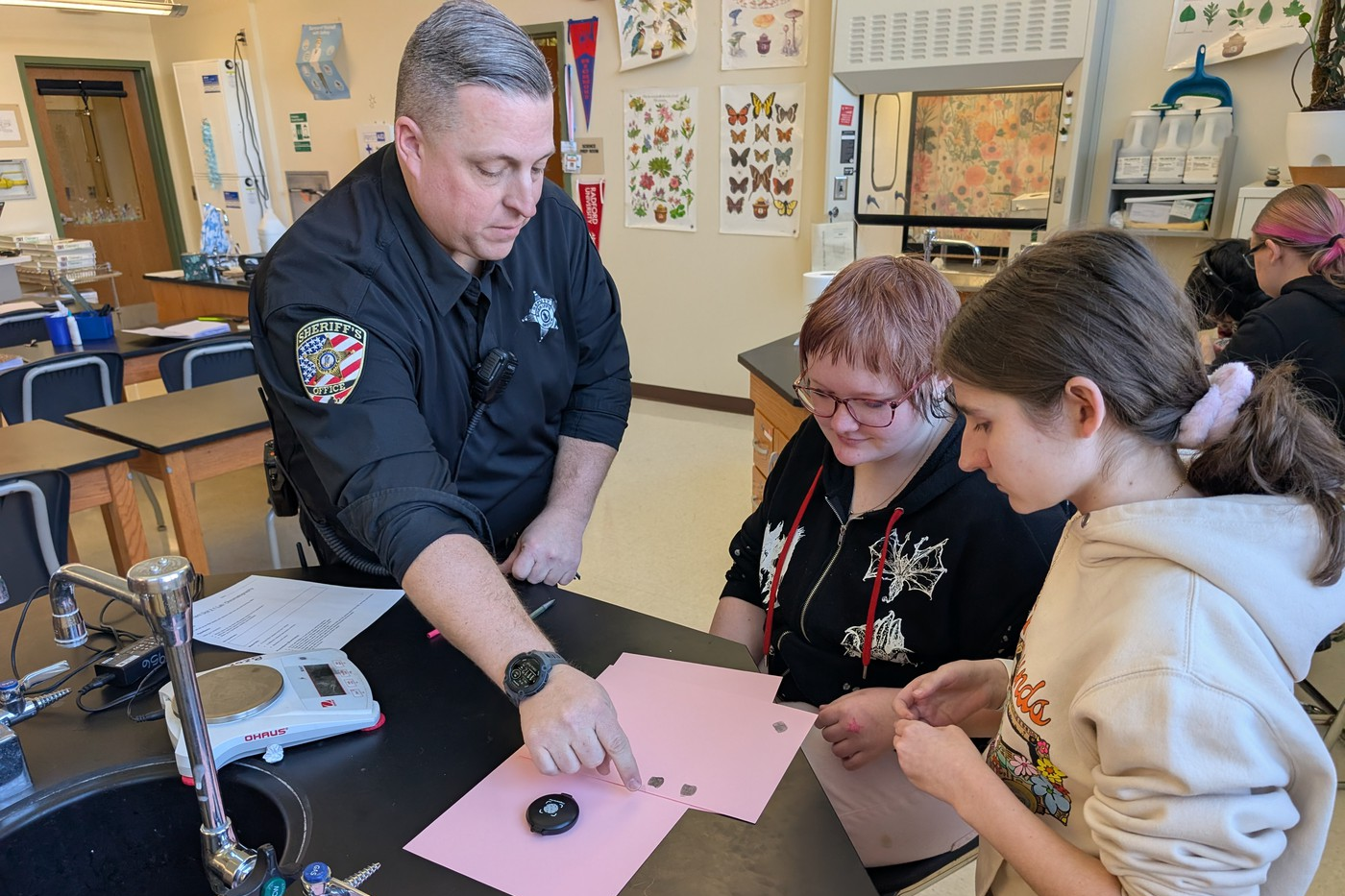 Man in police uniform working with studentns